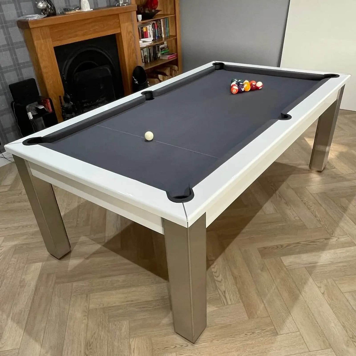 6ft pool table with black cloth and a white cabinet in a living room