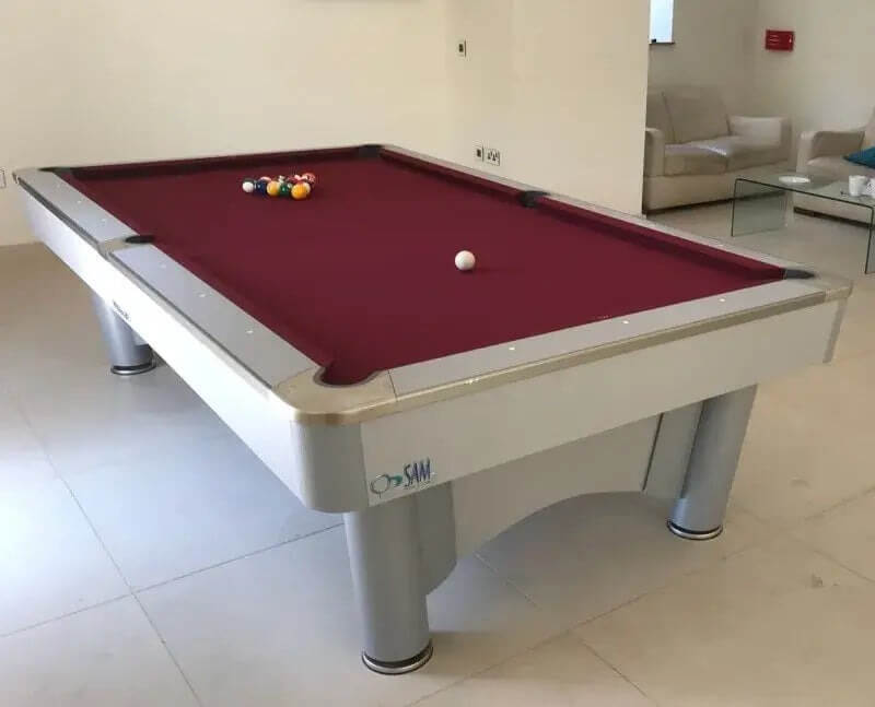 Coin operated pool table with burgundy cloth and a silver cabinet