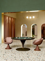 Round Asso poker table with green cloth and a brown leather cone base on a terrazzo floor