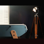 Light blue Eames inspired B90 football table end with beech leg beside a tripod floor lamp