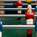 Close-up of red and blue Bonzini B90 players on chrome rods