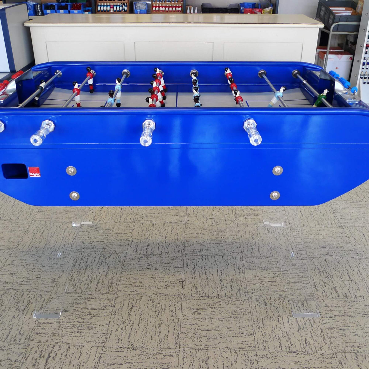 Side view of the blue B90 football table on clear Perspex legs