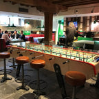 Long Bonzini giant football table set up in a restaurant bar beside bar stools
