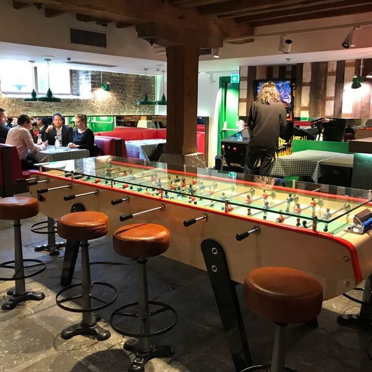 Long Bonzini giant football table set up in a restaurant bar beside bar stools