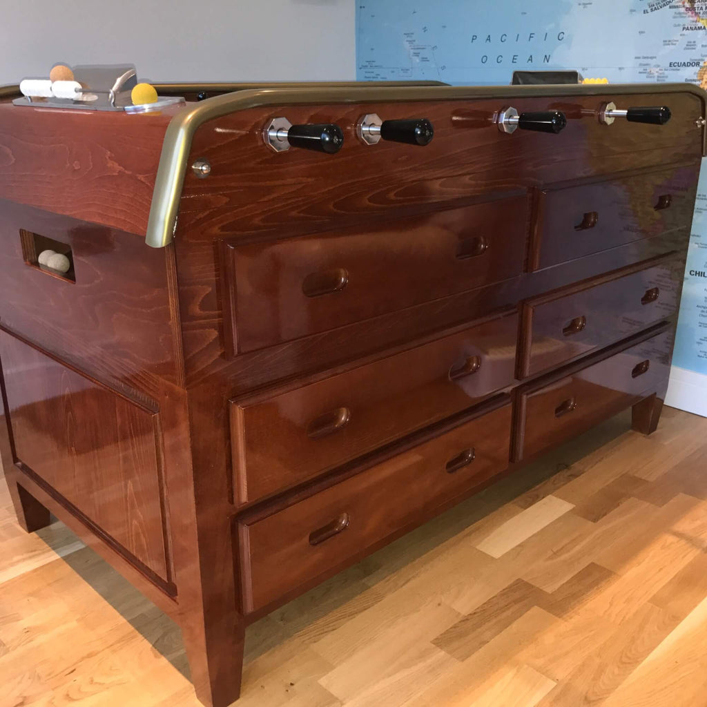 Cherry wood Grand Tiroirs football table showing its bank of drawers in a home