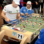 Two players competing on a Bonzini football table at a tournament