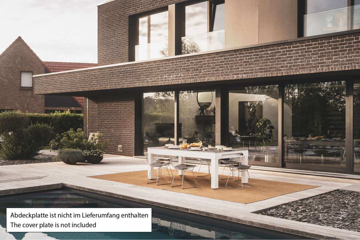 Cornilleau Classic Outdoor Pool Dining Table in White frame outdoors, wide view of the garden setting