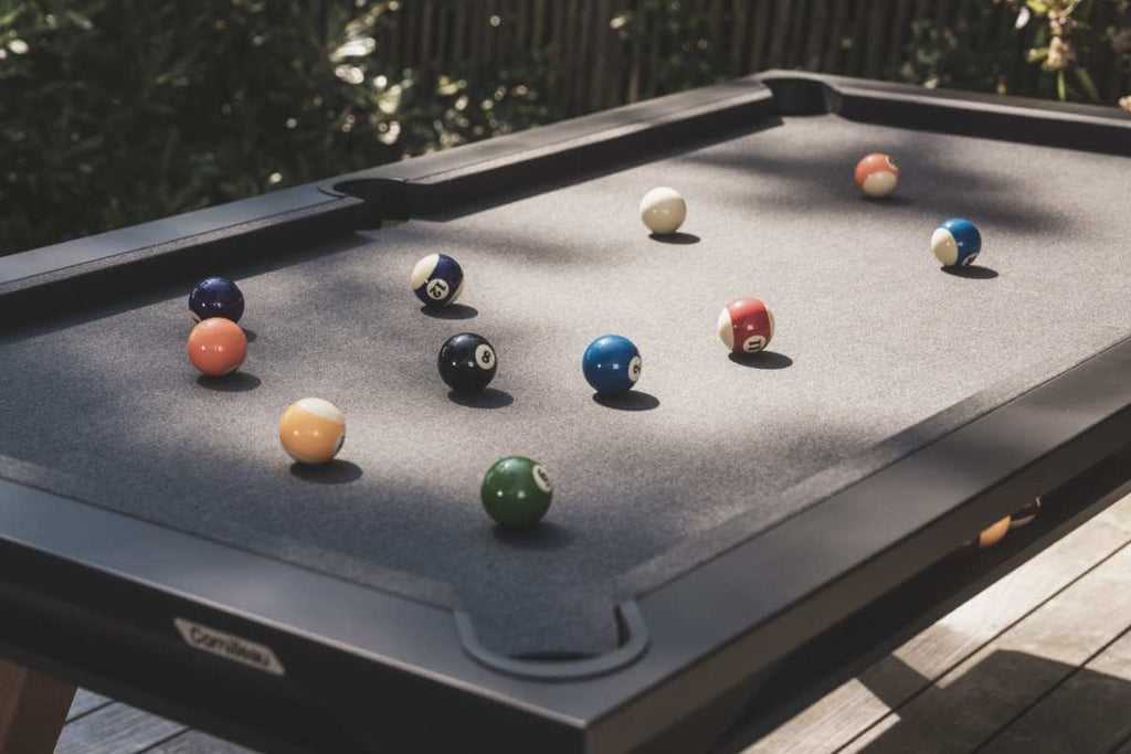 Black Cornilleau Origin outdoor pool table outside in a garden setting