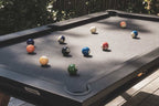 Black Cornilleau Origin outdoor pool table outside in a garden setting