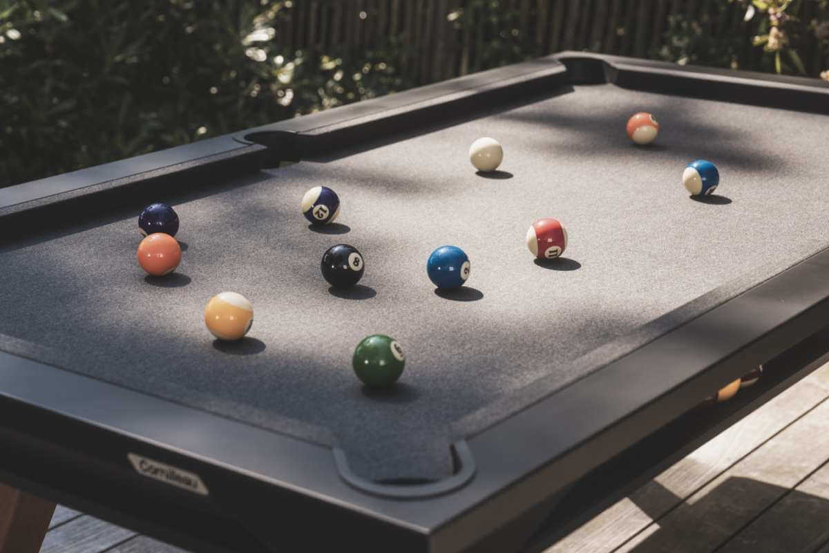 Black Cornilleau Origin outdoor pool table outside in a garden setting