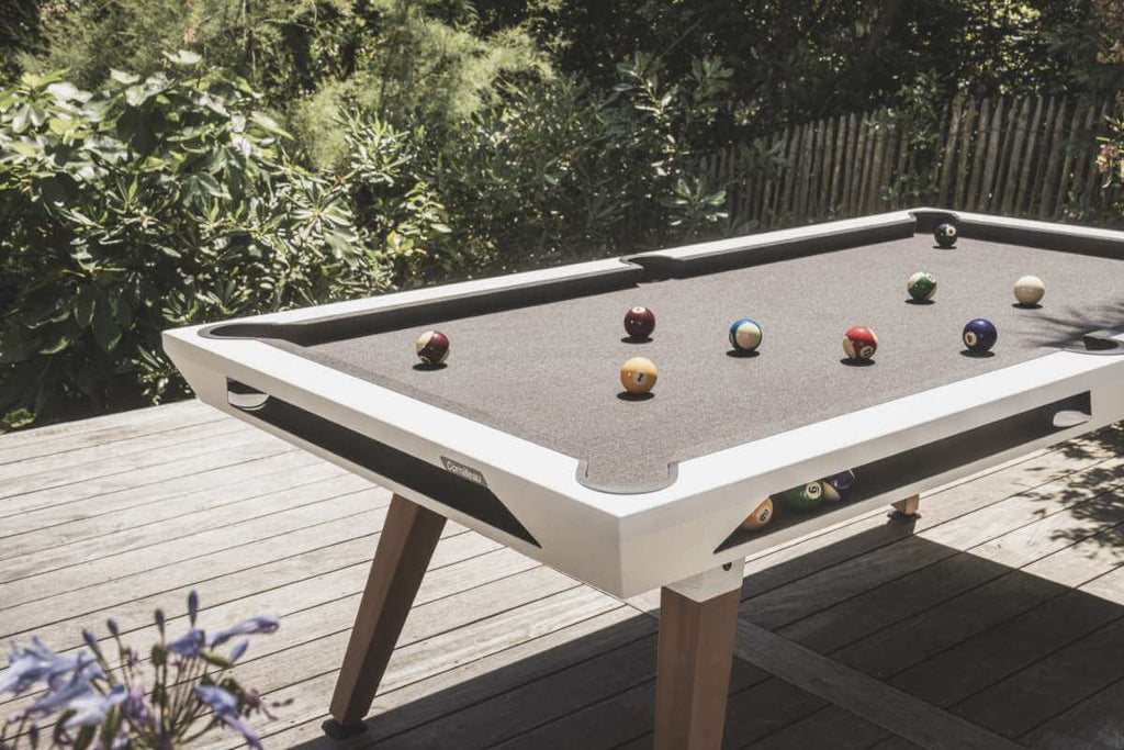 White Cornilleau Origin outdoor pool table set up on a patio, angled view