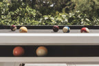 White Cornilleau Origin outdoor pool table outside in a garden setting