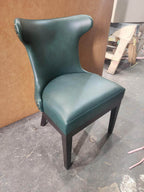 Green leather wingback poker chair with dark wood legs