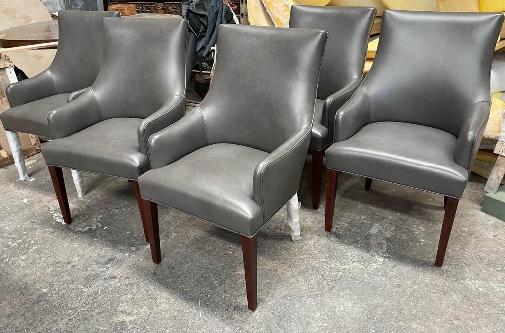 Four grey leather poker armchairs with dark wood legs