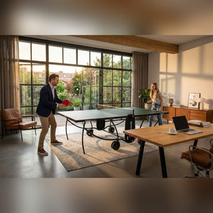 Two people playing on a green Heemskerk indoor table tennis table in a home office