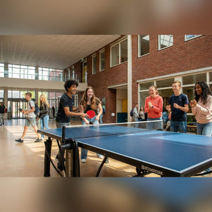 Students playing on a blue Heemskerk 2250 indoor table tennis table in a school hall