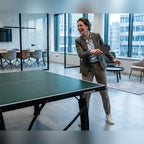 Woman playing on a green Heemskerk 2250 indoor table tennis table in an office