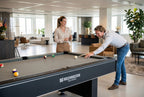 Colleagues playing pool on a Heemskerk Baltimore with grey cloth in an open-plan office
