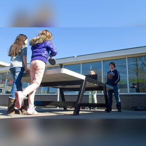 Children playing on a Heemskerk Beta concrete outdoor table tennis table outside a school