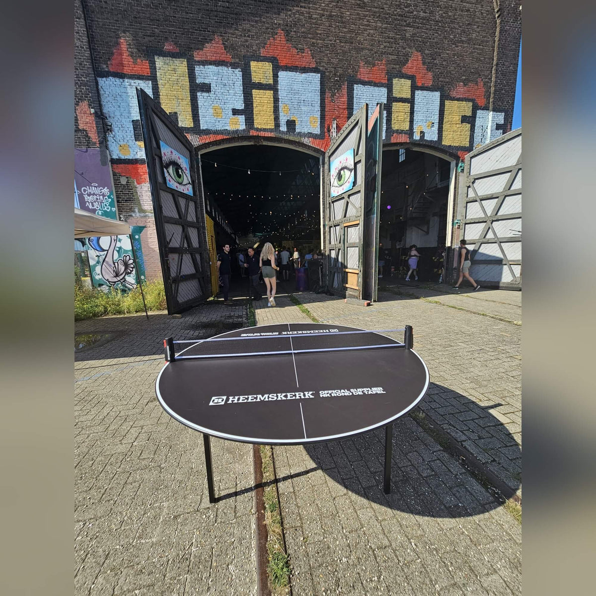 Heemskerk Circle round table tennis table set up in a street courtyard