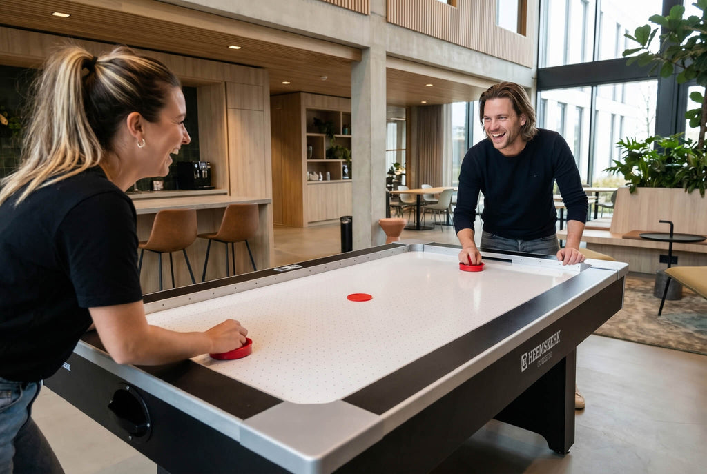 Two players facing each other across the Heemskerk Coliseum air hockey table