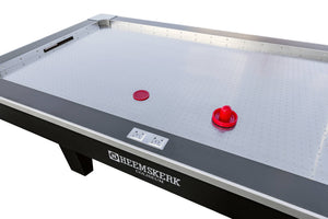 Red pucks and pushers on the Coliseum playfield next to the built-in score counter
