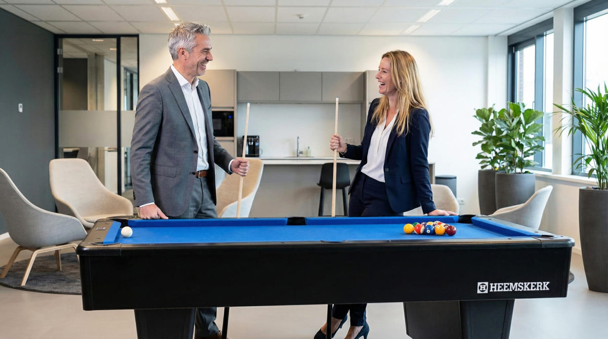 Two colleagues talking next to a Heemskerk Dallas pool table with blue cloth in a modern office