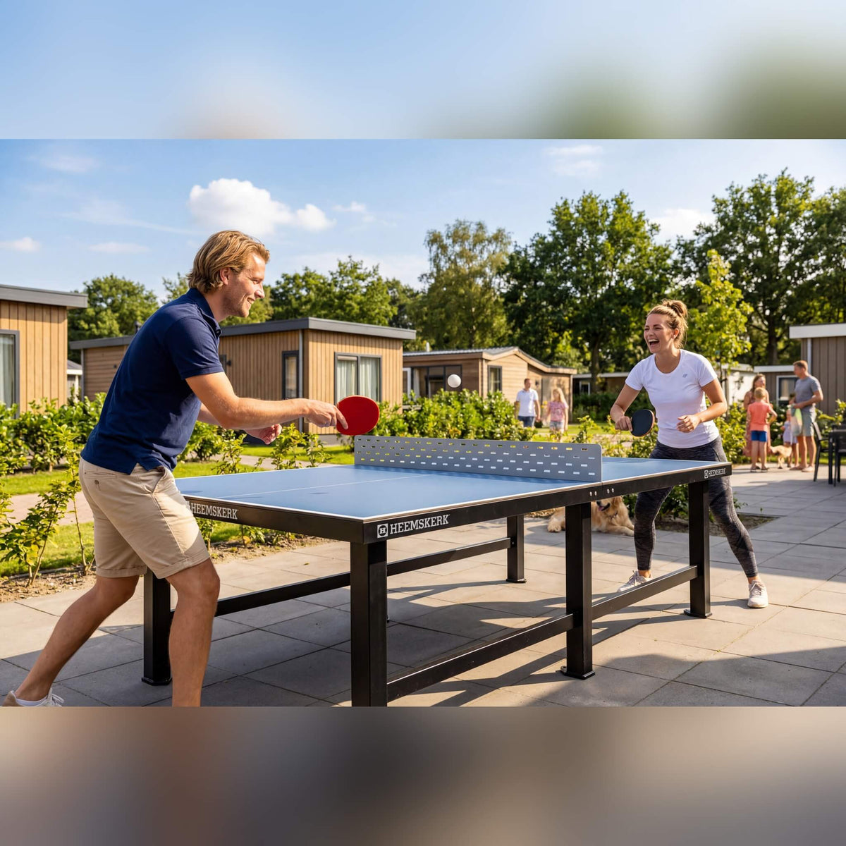 Two people playing on a Heemskerk Delta outdoor table tennis table at a holiday park