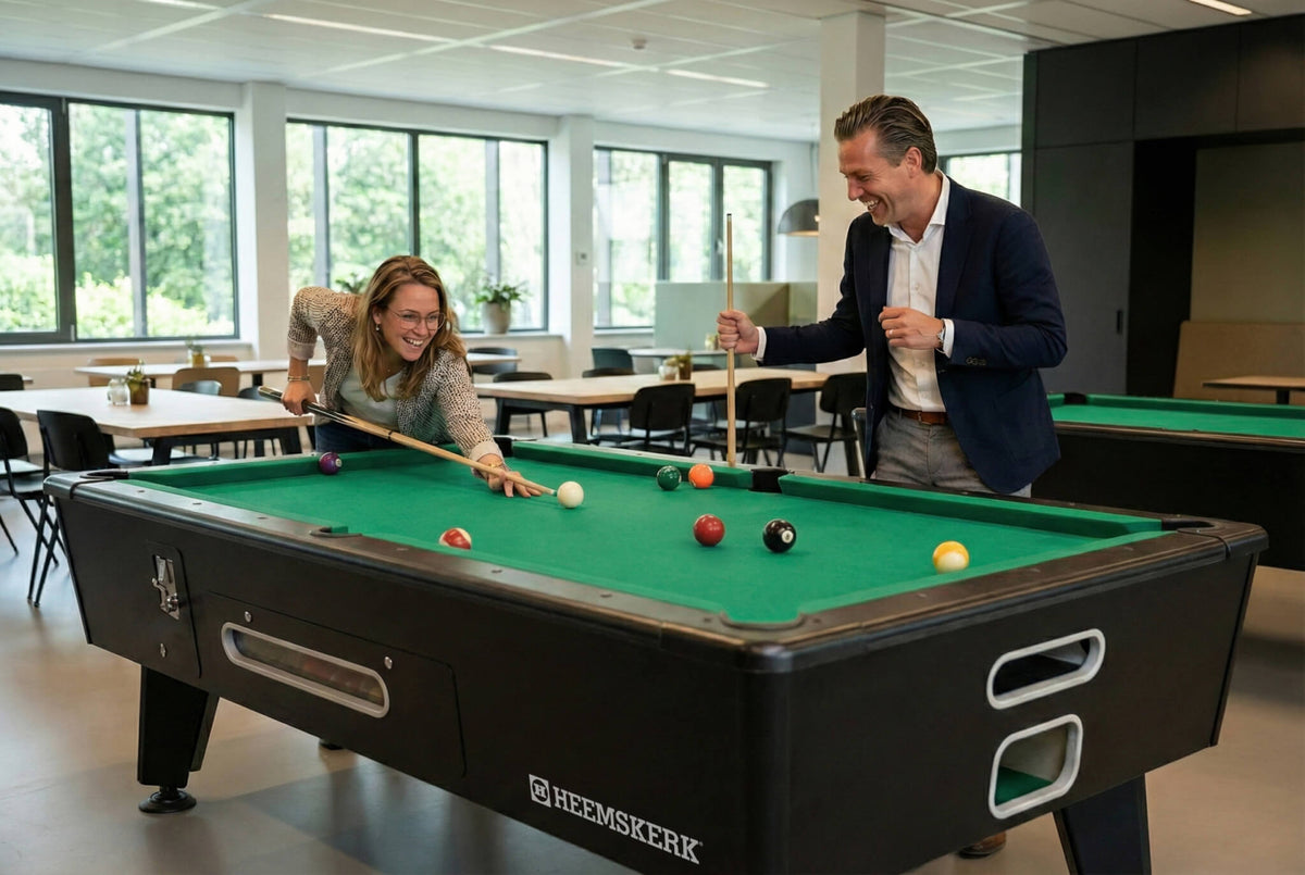 Two colleagues playing on a Kick Shot pool table with green cloth in a staff canteen
