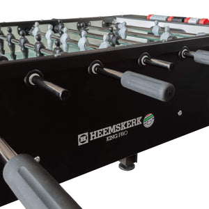 Handles and ball return on the black cabinet of the Heemskerk King Pro foosball table