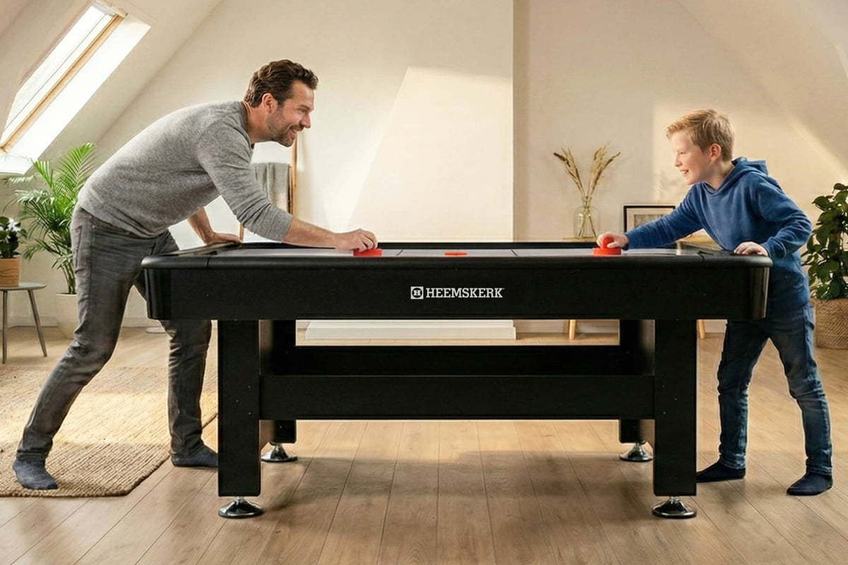 Father and son playing on the Heemskerk Masterplay air hockey table at home