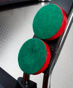 Two red pushers with green felt bases resting on the Heemskerk Navona playfield