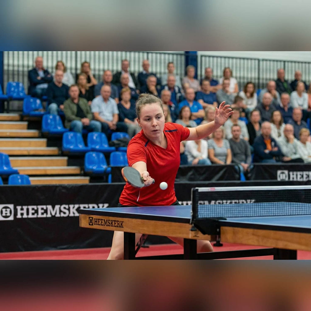 Player returning a shot on a blue Heemskerk Novi 2400 table tennis table at a match