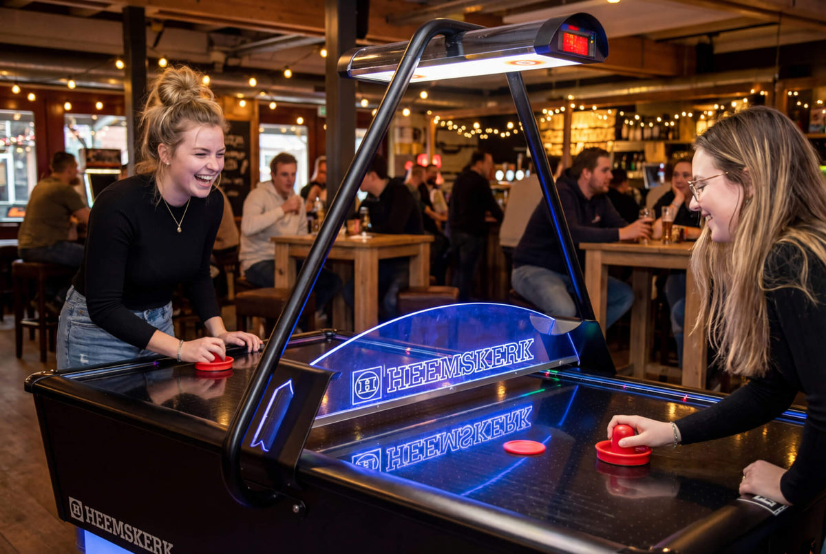 Two friends playing on the Heemskerk Parthenon air hockey table in a busy bar
