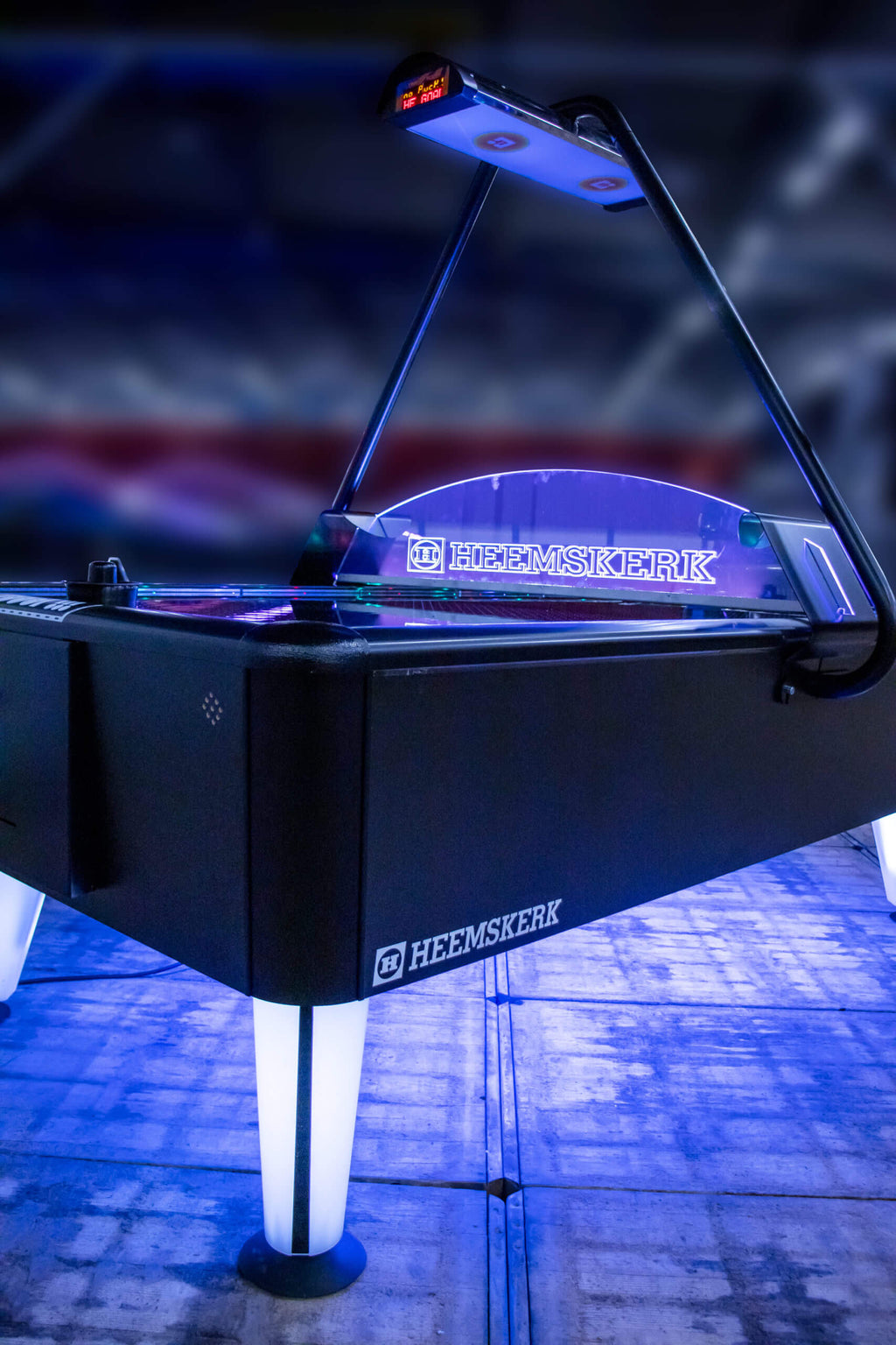 Heemskerk Parthenon air hockey table glowing with blue LED lighting in a dark room