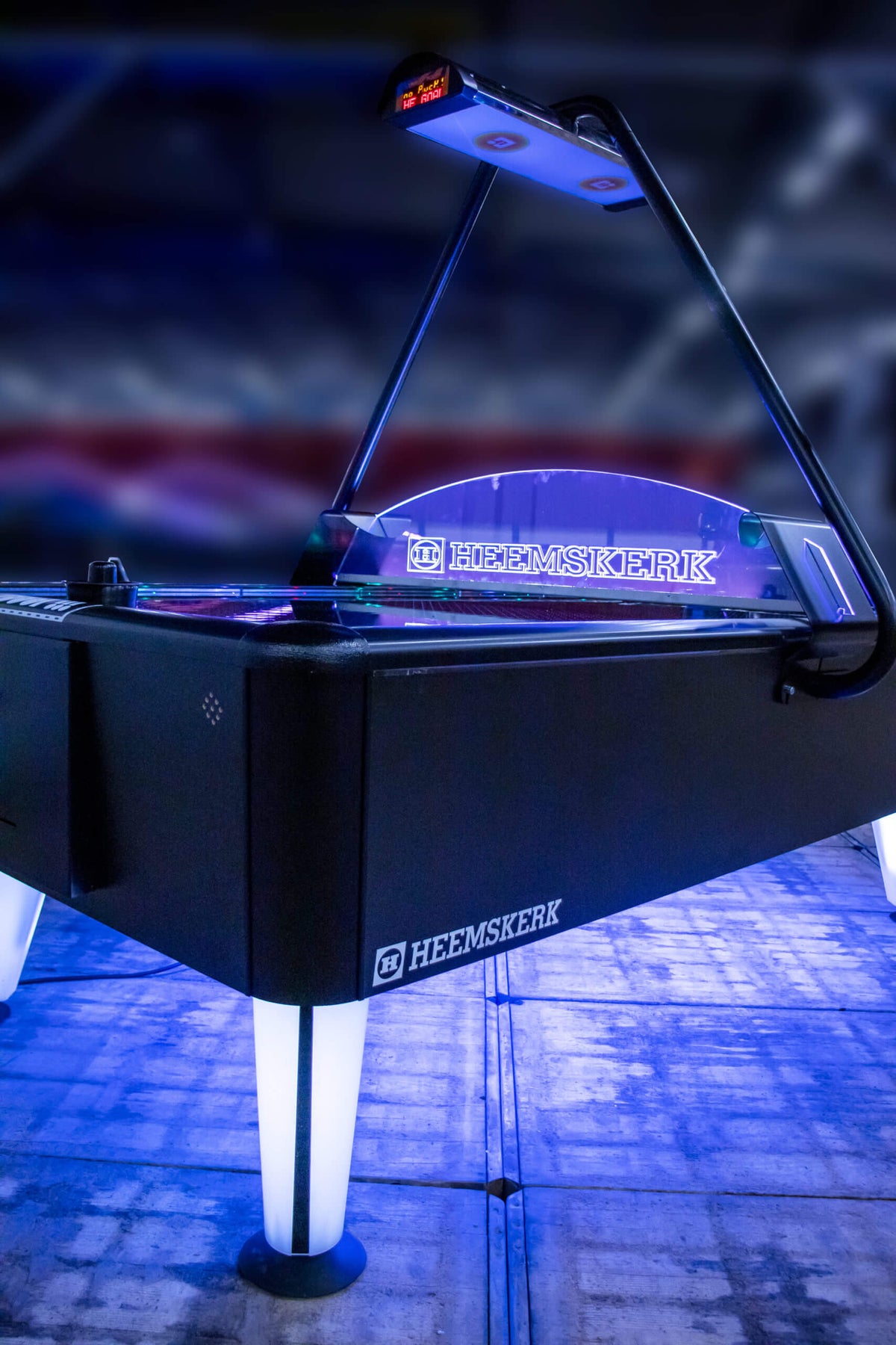 Heemskerk Parthenon air hockey table glowing with blue LED lighting in a dark room