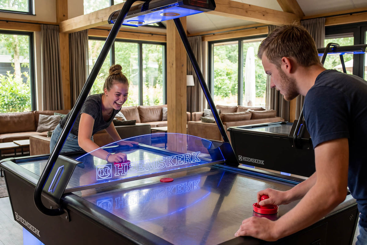 Two players in a fast game on the Heemskerk Parthenon air hockey table