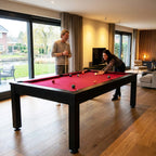 Two people playing pool on the black Heemskerk Richmond in a bright living room