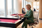 Woman working at a laptop on the black Heemskerk Richmond used as an office table