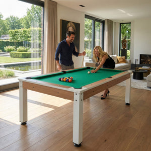 Couple playing pool on the Heemskerk Richmond Walnut in a living room with garden views