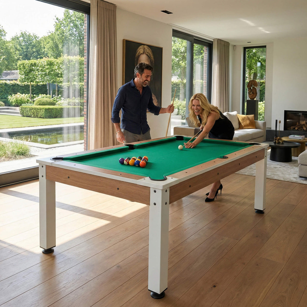 Couple playing pool on the Heemskerk Richmond Walnut in a living room with garden views