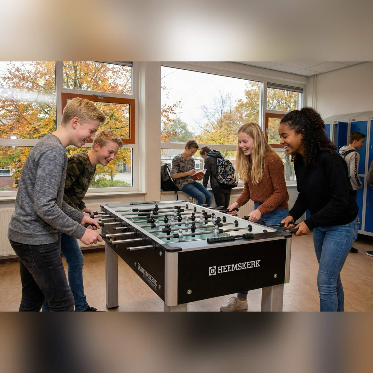 Students playing on a Heemskerk Soccer School football table in a school corridor