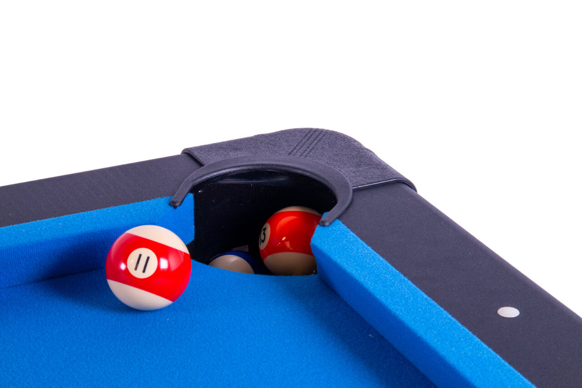 Close-up of a corner drop pocket on the Heemskerk Solid Feet pool table with pool balls