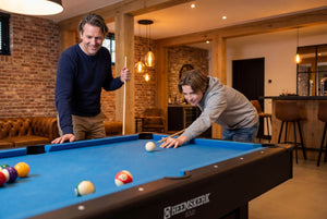 Two men playing on the Heemskerk Solid Feet pool table in a basement games room