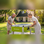 Couple playing on a Heemskerk Sunshine outdoor football table in a holiday park garden