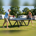 Two people playing on a Heemskerk Tango outdoor table tennis table at a campsite