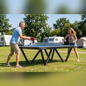 Two people playing on a Heemskerk Tango outdoor table tennis table at a campsite