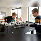 Two boys playing on a Heemskerk Time Out football table at a childcare centre
