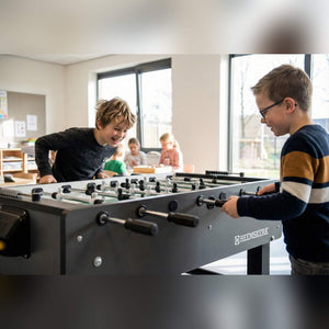 Two boys playing on a Heemskerk Time Out football table at a childcare centre