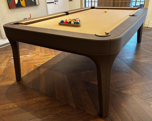 Luxury Dandy pool table in dark brown leather with sand cloth on a herringbone wooden floor
